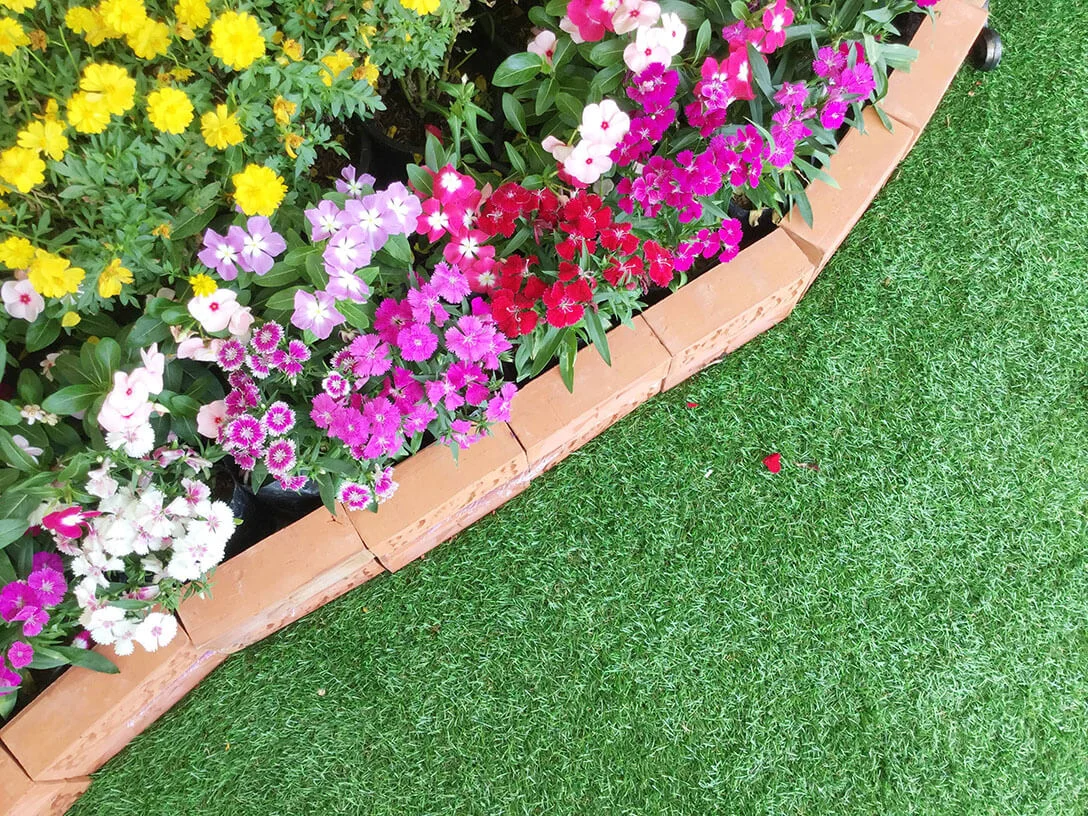 Synthetic Putting Green Installation in with Plants and Flowers